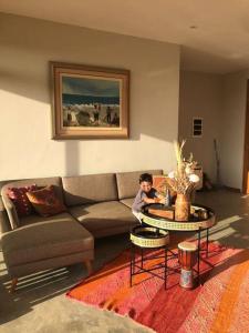 a young boy sitting in a living room with a couch at Casa Natural in Los Órganos