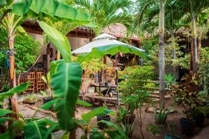 eine Gruppe von Menschen, die an einem Tisch im Garten sitzen in der Unterkunft Hostal Azul in Granada