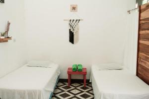 Zimmer mit 2 Betten und einem roten Tisch in der Unterkunft Hostal Azul in Granada