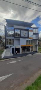Hotel RA04 في Chachagüí: مبنى كبير ازرق وابيض على شارع