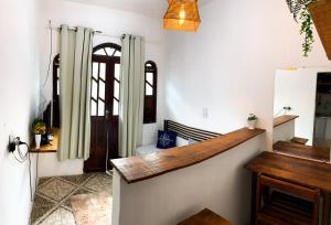 a hallway with white walls and a wooden stairway at Apartamento inteiro em Morro de São Paulo- Flats Maré mansa in Morro de São Paulo