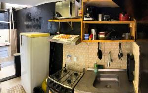Il comprend une petite cuisine équipée d'un évier et d'une cuisinière. dans l'établissement Apartamento inteiro em Morro de São Paulo- Flats Maré mansa, à Morro de São Paulo