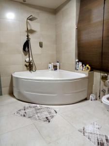 a white bath tub in a bathroom with a sink at بيت الاحلام للسكن الراقي in Cairo