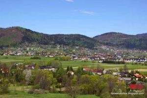 una ciudad en un campo con montañas en el fondo en Lipowa Nest, en Lipowa