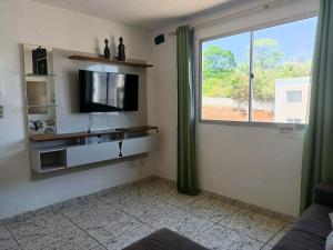 a living room with a tv and a window at Apartamento inteiro próximo aeroporto de Confins in Vespasiano