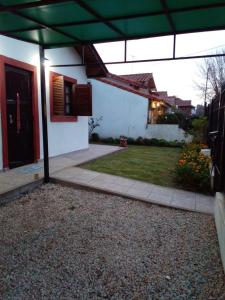uma casa com um guarda-chuva verde num quintal em Casa en Punta Mogotes em Mar del Plata