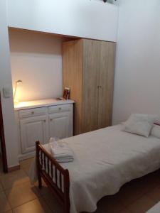 um pequeno quarto com uma cama e um armário em Casa en Punta Mogotes em Mar del Plata