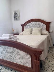 sypialnia z łóżkiem z drewnianą ramą w obiekcie Casa Morería w mieście Guadalcanal