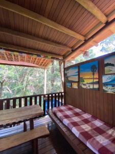 a wooden porch with a bench and a table at Pousada Natureza Viva in Itacaré +122 photos
