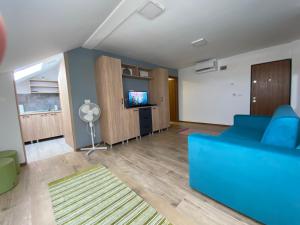 sala de estar con sofá azul y TV en Netflix Cloud 2, en Timisoara