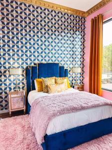 a bedroom with a blue bed and a blue and white wall at Dolly's Art Deco - Luxe Stay Near Broadway in Nashville
