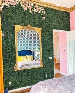 a bedroom with a green wall with a mirror at Dolly's Art Deco - Luxe Stay Near Broadway in Nashville