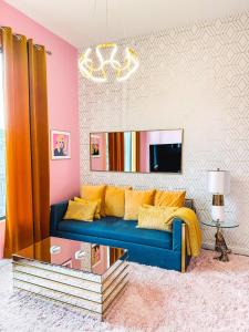 ein Wohnzimmer mit einem blauen Sofa und einem Spiegel in der Unterkunft Dolly's Art Deco - Luxe Stay Near Broadway in Nashville