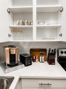 a kitchen with white cabinets and a coffee maker on a counter at Dolly's Art Deco - Luxe Stay Near Broadway in Nashville