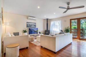 a living room with a couch and a tv at The Panoramic Tree View Home in Melbourne City in Melbourne