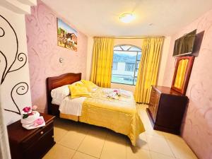 1 dormitorio con 1 cama y una ventana con cortinas amarillas en Hostal Grand Rio, en Baños