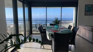 una mesa y sillas en una habitación con vistas al océano en Kaili Ocean view luxury 2BR AC throughout Fiber Wifi & Pool, en Papeete