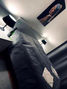ein Schlafzimmer mit einem Bett und einer Lampe und einem Bild eines Mannes in der Unterkunft S8 Luxury 1-Bedroom Apt OldTown - Foodstore, PCscreen, HBOmax, Unlimited Music, Crib, BabyChair, FastWifi in Košice