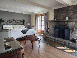 a bedroom with a large bed and a fireplace at Auberge des Nuages in La Malbaie