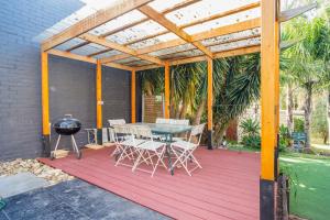 a patio with a table and chairs and a grill at The Panoramic Tree View Home in Melbourne City in Melbourne