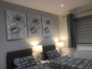 two beds in a bedroom with flowers on the wall at Amber Apartments, FREE PARKING, 3 bedrooms, sleeps 5, 1 en-suite plus 1 bath/shower room in Swindon