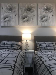 two beds in a bedroom with two posters on the wall at Amber Apartments, FREE PARKING, 3 bedrooms, sleeps 5, 1 en-suite plus 1 bath/shower room in Swindon