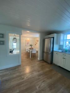 een keuken en eetkamer met een tafel en een koelkast bij Private Room- Shediac Beach House in Shediac