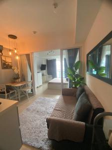 uma sala de estar com um sofá e um quarto com uma cama em Condo Azure Staycation in Paranaque Beach View em Manila