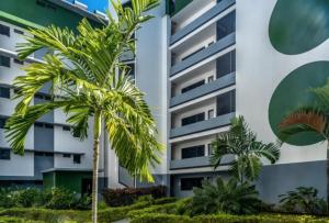 a building with palm trees in front of it at Kaili Ocean view luxury 2BR AC throughout Fiber Wifi & Pool in Papeete