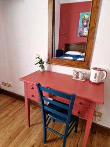 羅馬的住宿－Pepe's Place - Carlo Alberto，红色的书桌,配有蓝色的椅子和镜子