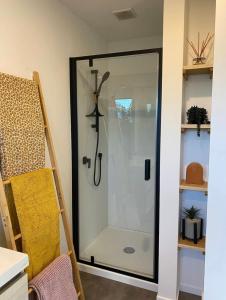 a shower with a glass door in a room at Private by the beach in Whitianga