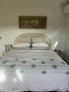a bed with two pillows on top of it at Private by the beach in Whitianga