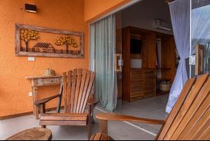 a living room with a chair and a table and a window at LOFT café da manhã e piscina ! in Trancoso