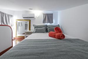 um quarto com uma cama com toalhas vermelhas em Duplex PLAZA MAYOR by MONARO***** em Madri