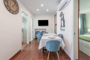 uma sala de jantar com mesa e cadeiras e um relógio em Duplex PLAZA MAYOR by MONARO***** em Madri