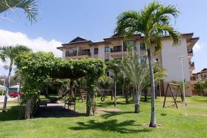 um edifício com um parque com palmeiras e um baloiço em VG Sun Cumbuco 4 Pessoas Nascente WiFi em Cumbuco