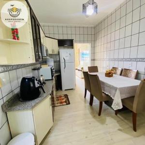 a kitchen and dining room with a table and a refrigerator at Hospedagem Praia Central in Navegantes