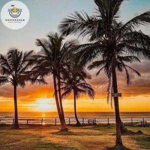 dwie palmy na plaży o zachodzie słońca w obiekcie Hospedagem Praia Central w mieście Navegantes