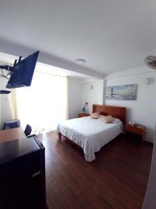 a bedroom with a bed and a flat screen tv at Hotel Golf Paracas in Paracas