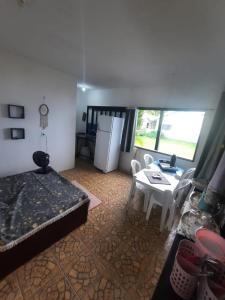 Zimmer mit einem Bett, einem Tisch und einem Kühlschrank in der Unterkunft São Francisco do Sul - Vila da Glória - Falansterio dos Franceses in São Francisco do Sul