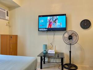 Schlafzimmer mit einem TV an der Wand und einem Ventilator in der Unterkunft Avida Towers Riala Tower 3 in Cebu City