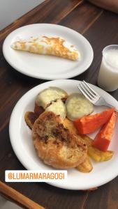 dos platos blancos de comida en una mesa de madera en Pousada LuMar Maragogi, en Maragogi