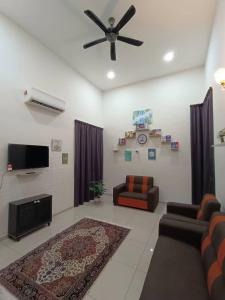 a living room with a couch and a ceiling fan at Homestay Teacher,Perak, Gerikmist in Gerik