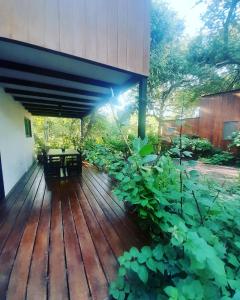 a wooden deck with a picnic table and plants at Mola Mola Surf Popoyo in Popoyo