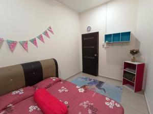 um quarto com uma cama com lençóis cor-de-rosa e uma bandeira em Homestay Teacher,Perak, Gerikmist em Gerik