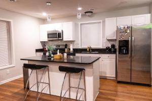 een keuken met witte kasten en een roestvrijstalen koelkast bij HOAPS in Minneapolis