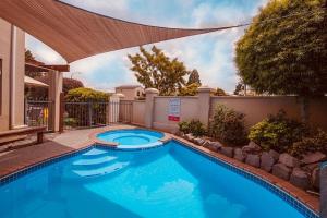 a swimming pool in a backyard with a large blue pool at Apartment Fourteen in Taupo