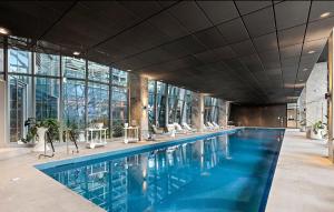 a large swimming pool in a building with windows at Supreme Sub-Penthouse - 3 Bedroom 2 Bathroom Melbourne CBD in Melbourne
