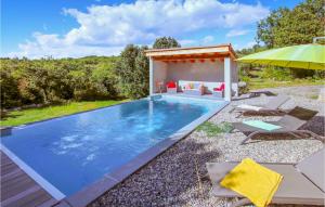 una piscina con sillas y sombrilla en Lovely Home In Labeaume With Kitchenette, en Labeaume