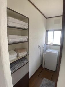 baño con armario con toallas y nevera en 落ち着きのある安らぎ空間／新千歳空港から30分の一棟貸し民家, en Chitose